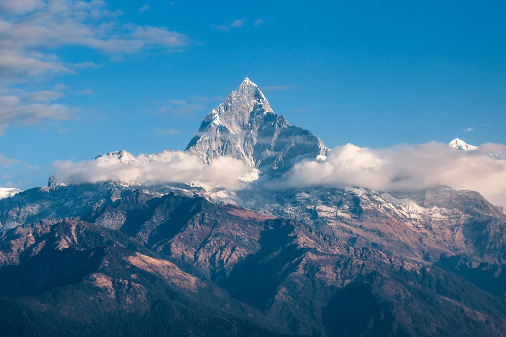 Einzelner Berg über den Wolken. Bergspitze vor blauem Himmel